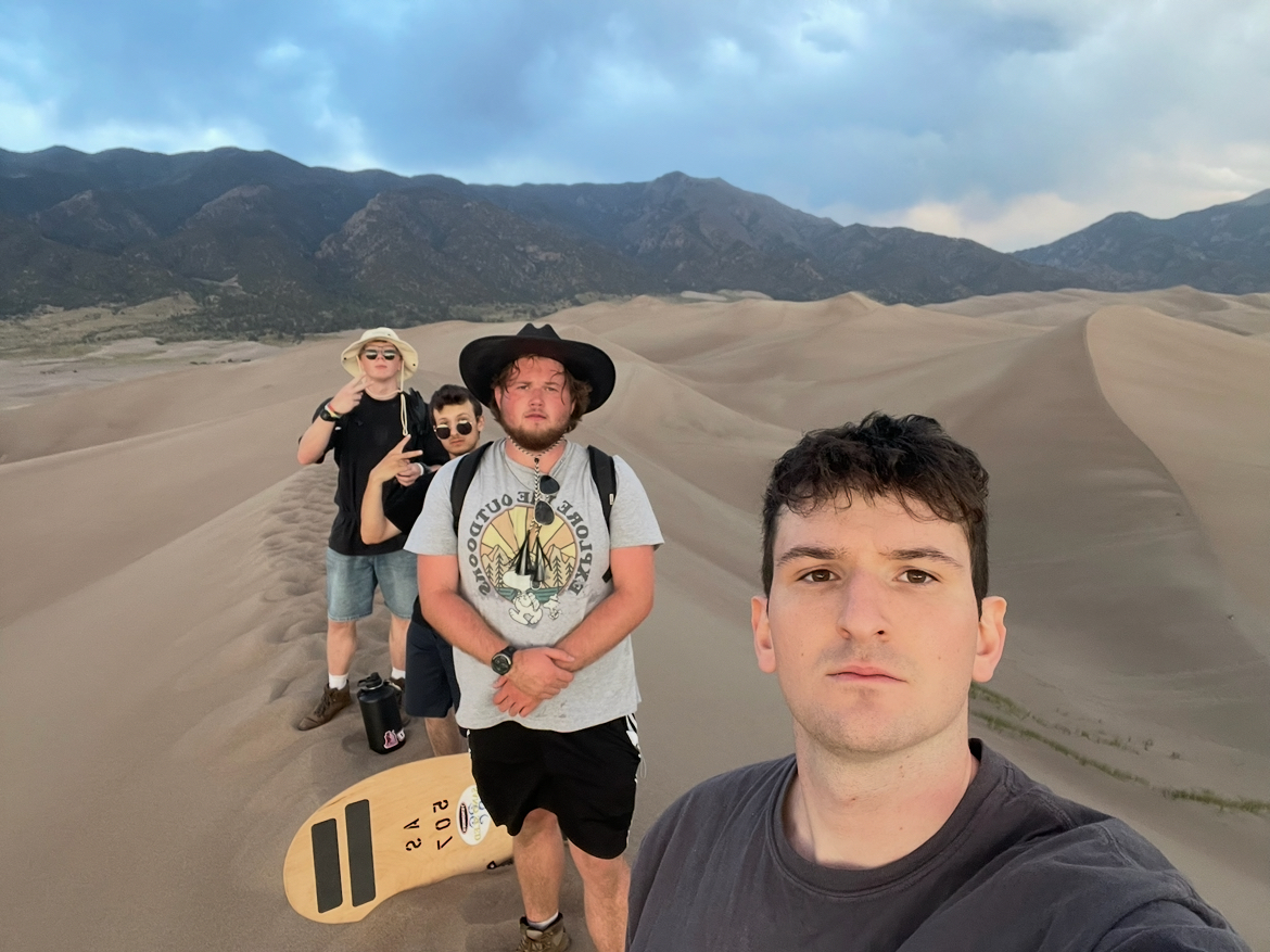 Mike and three friends sandboarding on the Great Sand Dunes